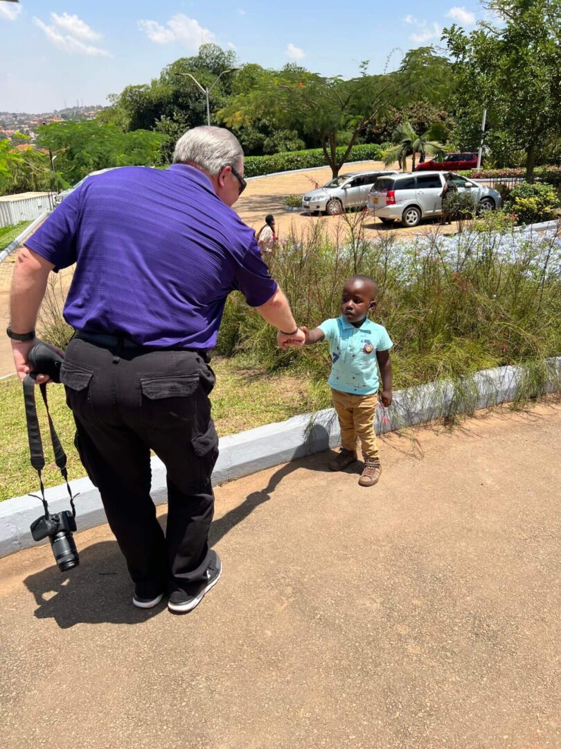 A Man in a Blue Shirt Shaking Hands With a Boy