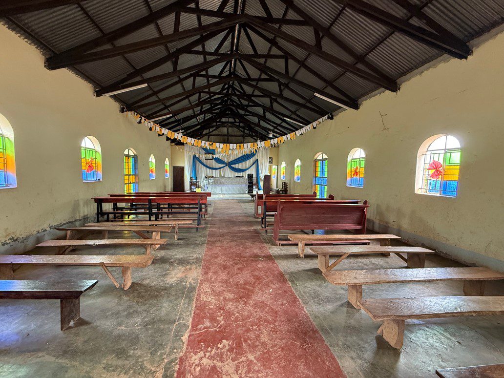 Rustic chapel aisle with colorful stained-glass windows