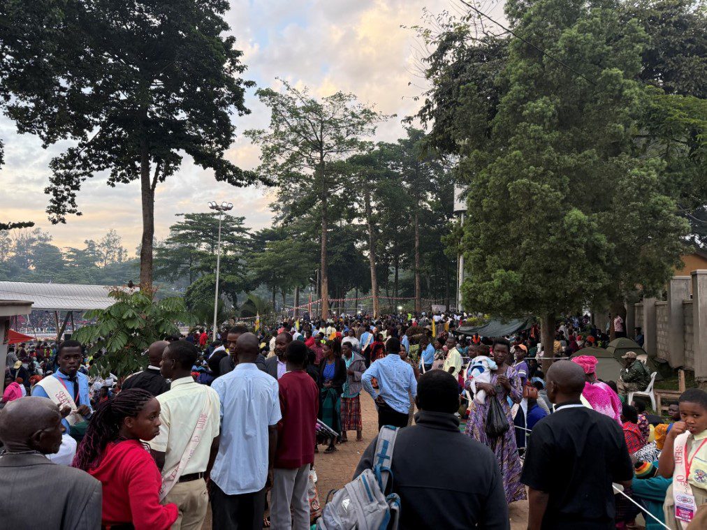 Crowd of people walking along tree-lined street