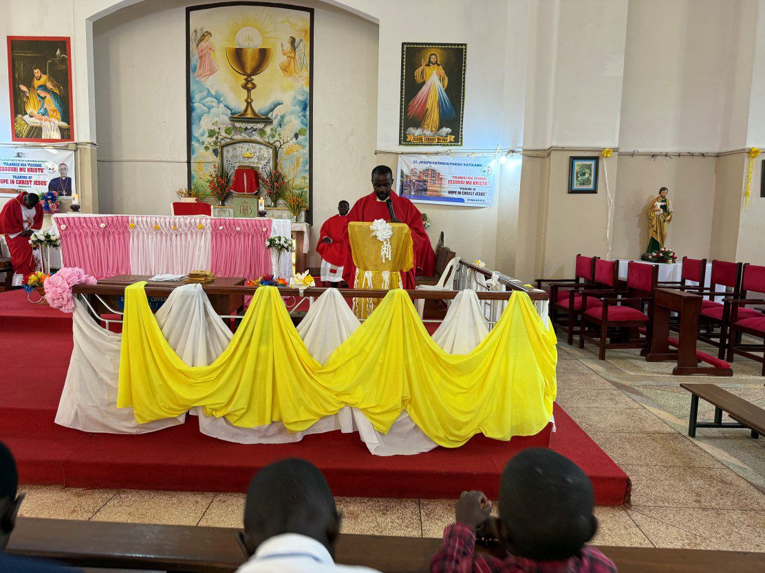 Priest in red at decorated church altar