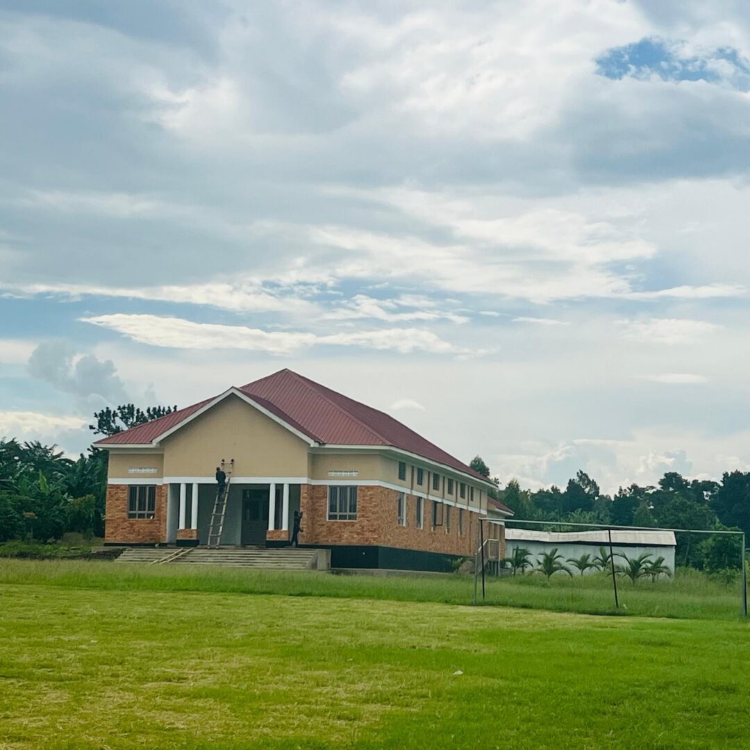 Brick building with red roof and green lawn
