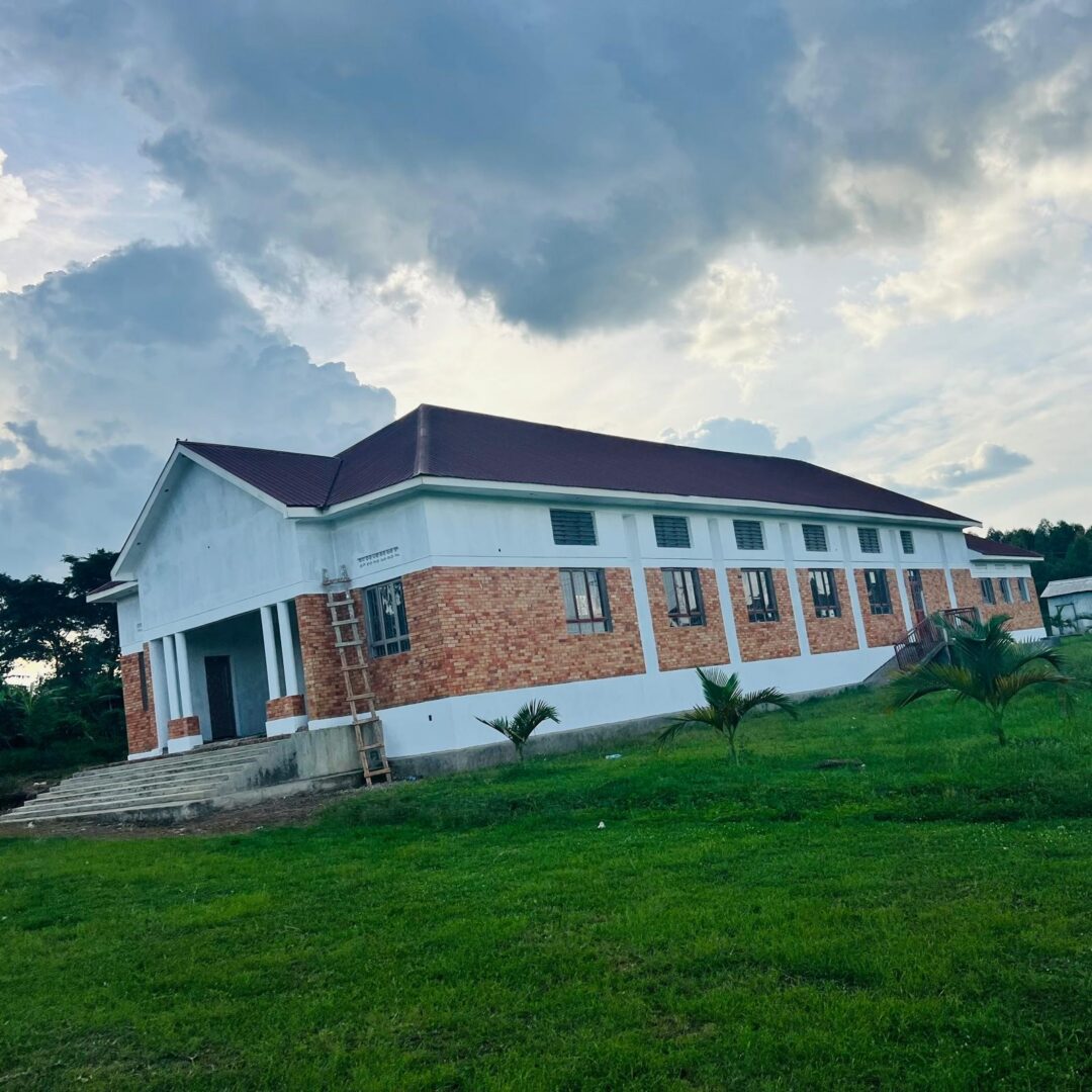 Long brick and white building on grassy field